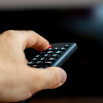 TV Free male hand holding tv remote trying turn tv